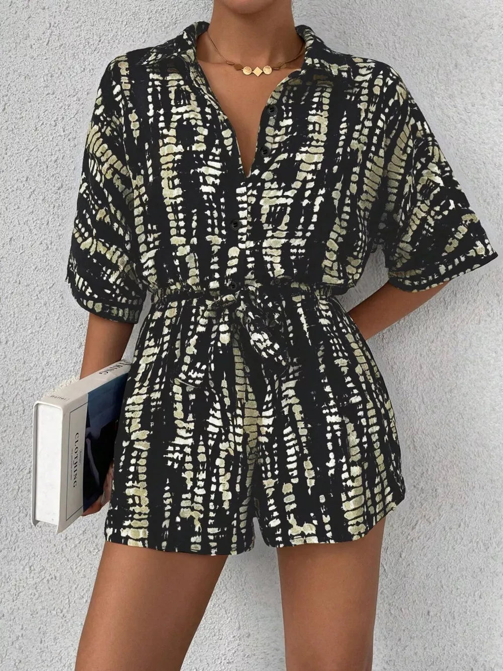 Black and white tie-dye belted romper with collared neckline and button front.