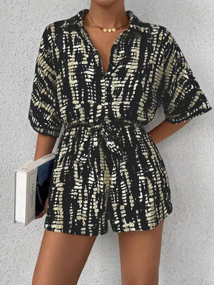 Black and white tie-dye belted romper with collared neckline and button front.