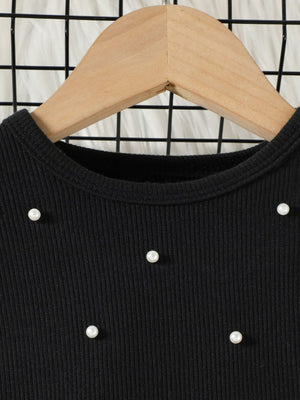 Black toddler top with pearl embellishments and ribbed texture.