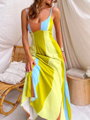 Vibrant color block maxi dress with blue, yellow, and brown panels, featuring spaghetti straps and a flowing skirt with side