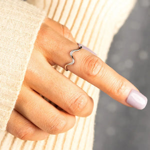 Serpentine diamond contour ring in silver with a wavy design and sparkling stones.