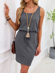 Sleeveless gray waffle-knit dress with drawstring waist and tassel detail.