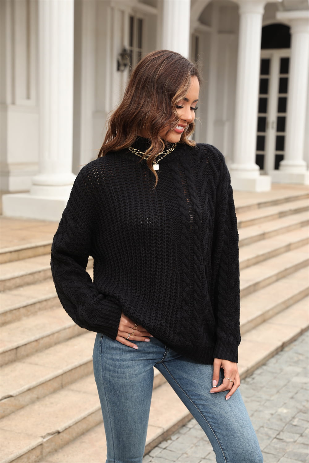 Black cable-knit turtleneck sweater with voluminous silhouette and textured acrylic knit.