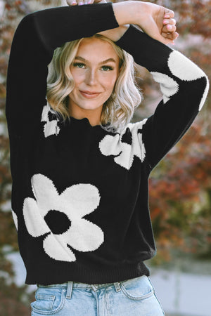 Black acrylic crewneck sweater with white floral intarsia pattern.
