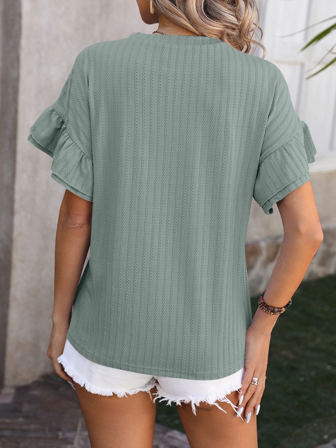 Sage green textured blouse with flutter sleeves and vertical ribbing.