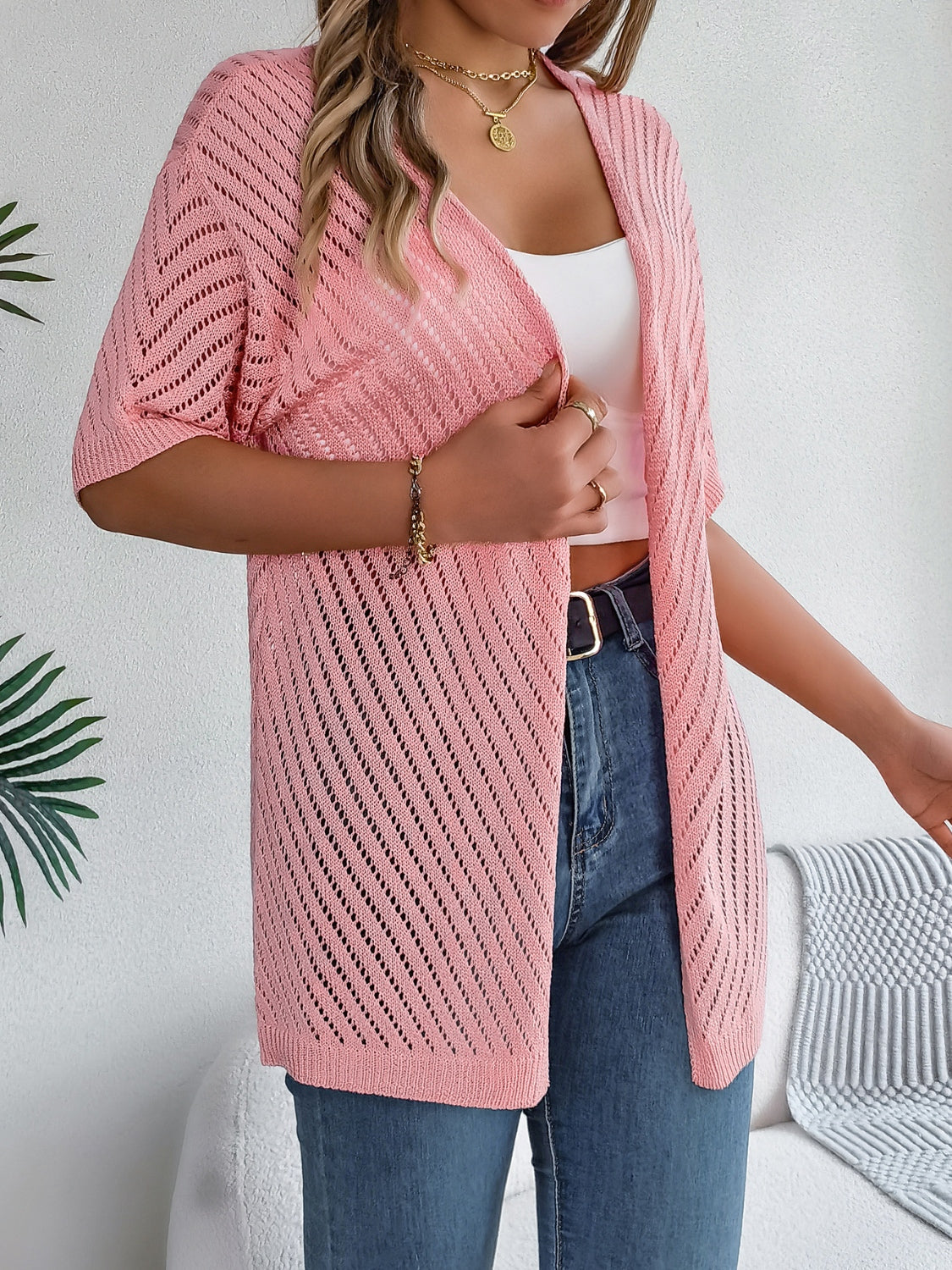 Pink open-knit slouchy cardigan with short sleeves and a chevron pattern.