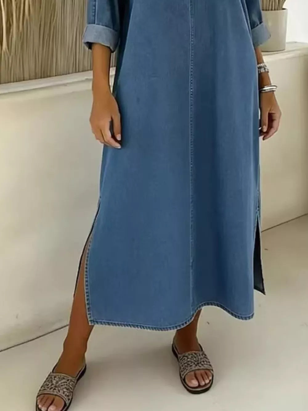 Light blue denim midi dress with V-neck, cuffed sleeves, and side slit.