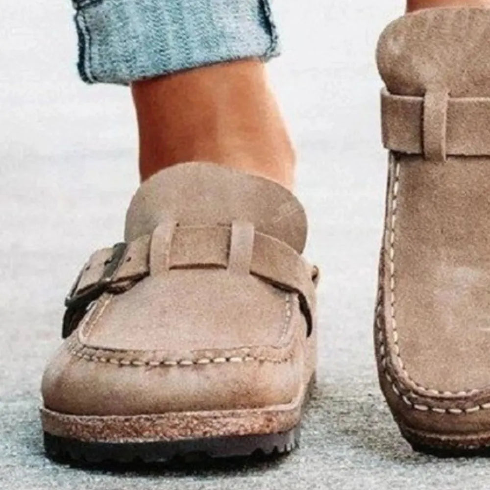 Caramel suede buckle mule loafers with contrast stitching and adjustable strap.
