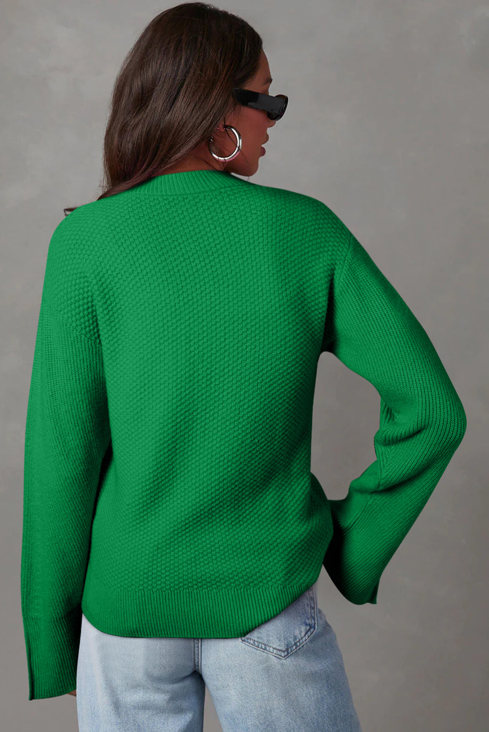 Green knit sweater with textured pattern and slit sleeves, crew neck, long sleeves.