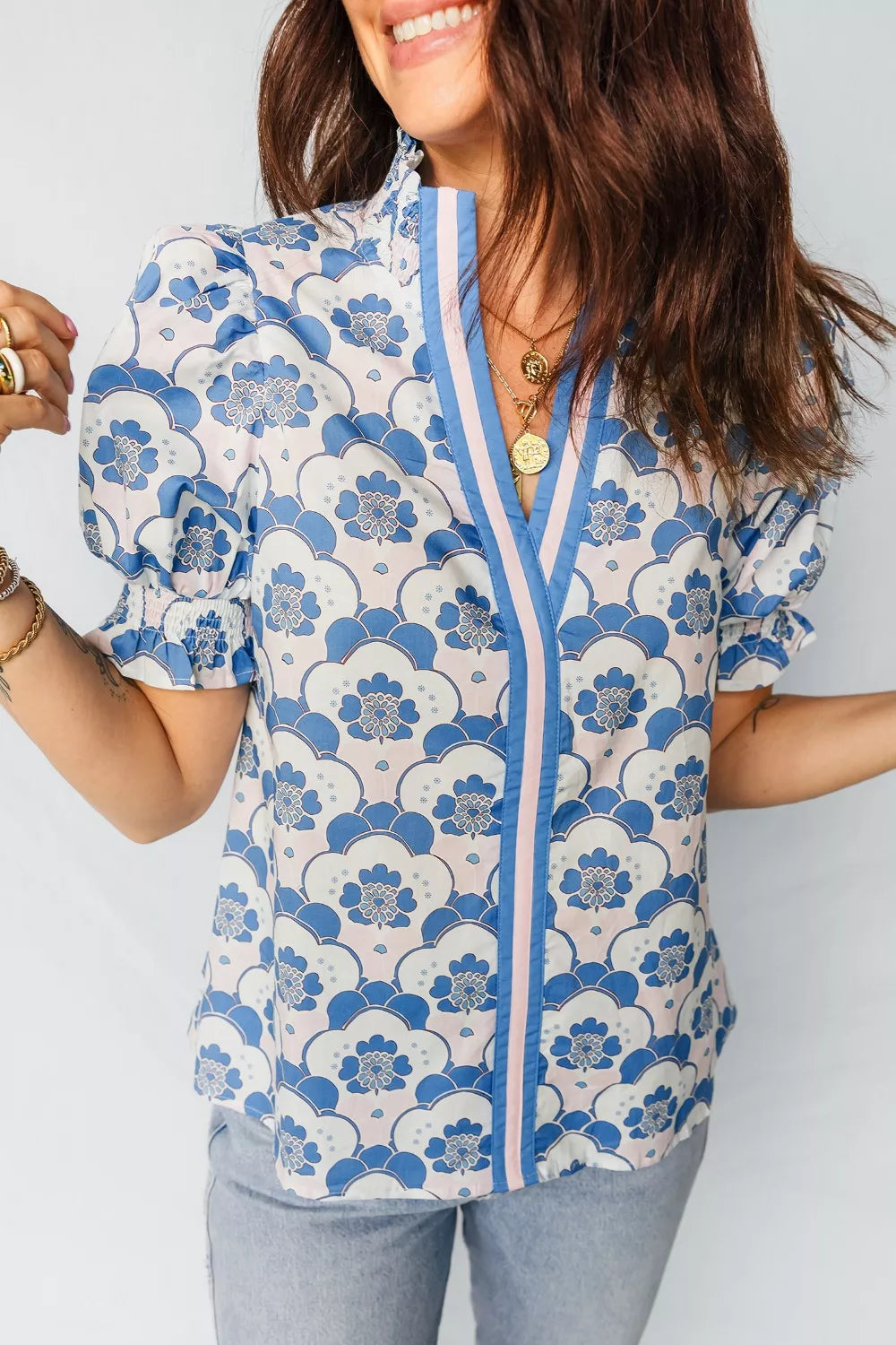 Playful floral print polyester blouse with puff sleeves, ruffled cuffs, and a V-neck with striped trim.