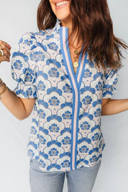 Playful floral print polyester blouse with puff sleeves, ruffled cuffs, and a V-neck with striped trim.