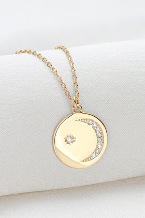 Gold celestial pendant necklace with moon and star charms and crystal accents.