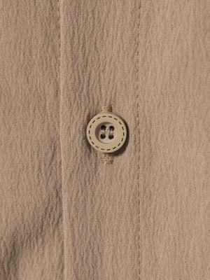 Men's plus-size beige button-up shirt with textured fabric and a round button detail.
