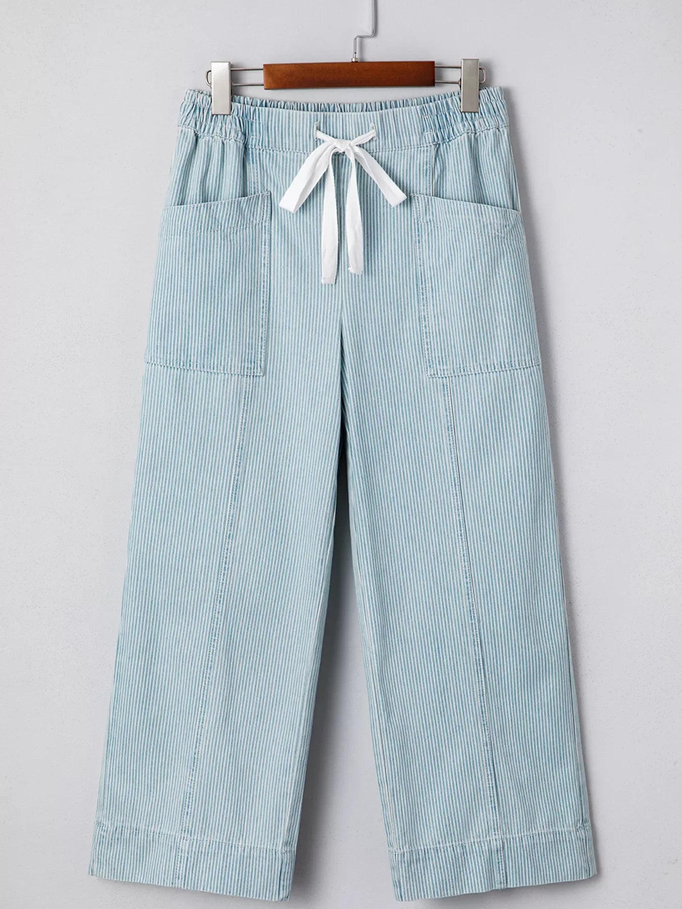Light blue striped mid rise drawstring jeans with wide legs and front pockets.