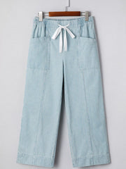 Light blue striped mid rise drawstring jeans with wide legs and front pockets.