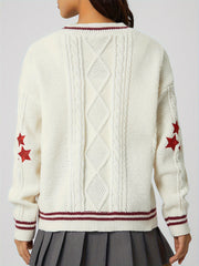 White cable knit cardigan with red stars and striped trim.
