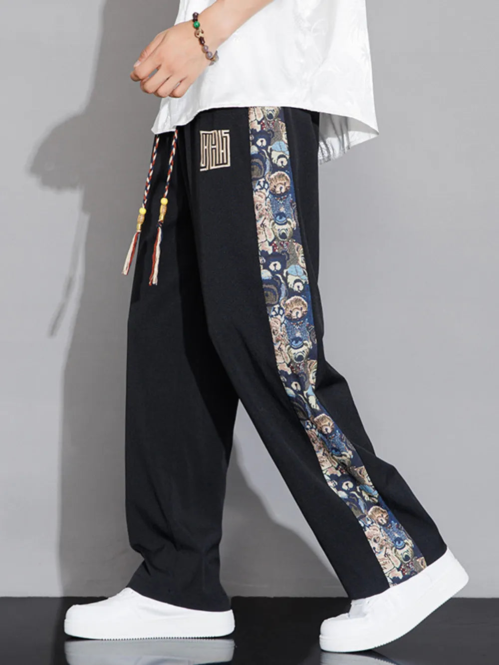 Men's black sweatpants with printed side stripe and drawstring.