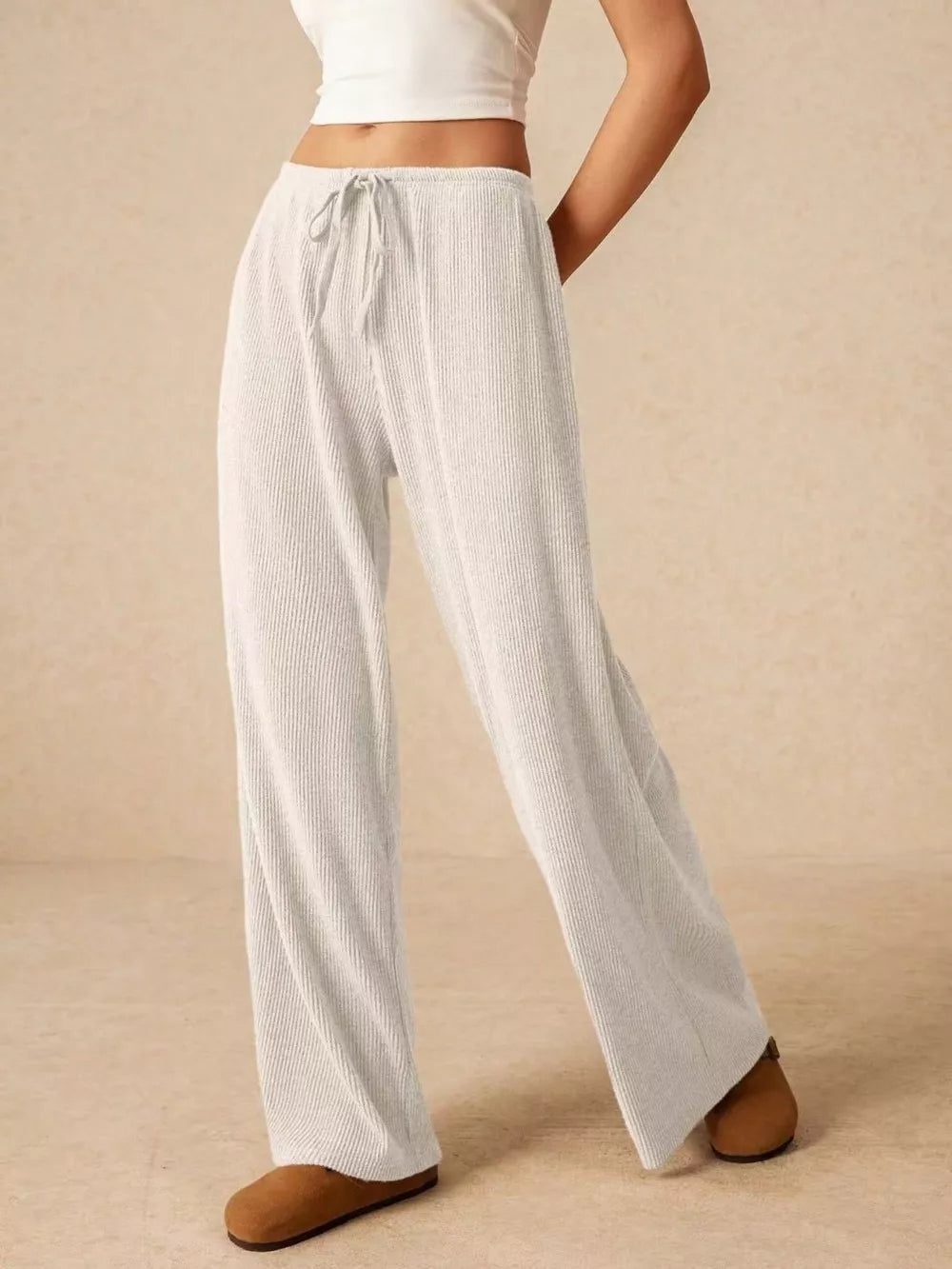 White ribbed wide-leg drawstring pants with a relaxed fit.