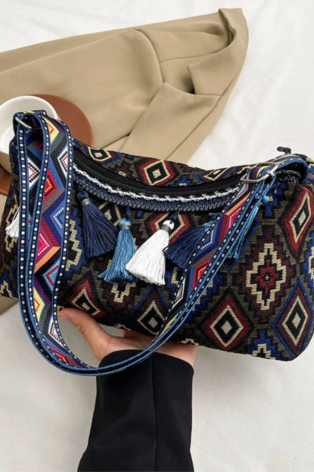Geometric embroidered shoulder bag with tassels and colorful woven strap