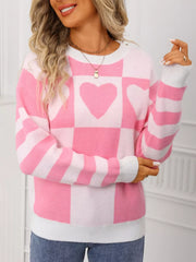 Blush pink and white checkerboard knit sweater with heart details and striped sleeves.