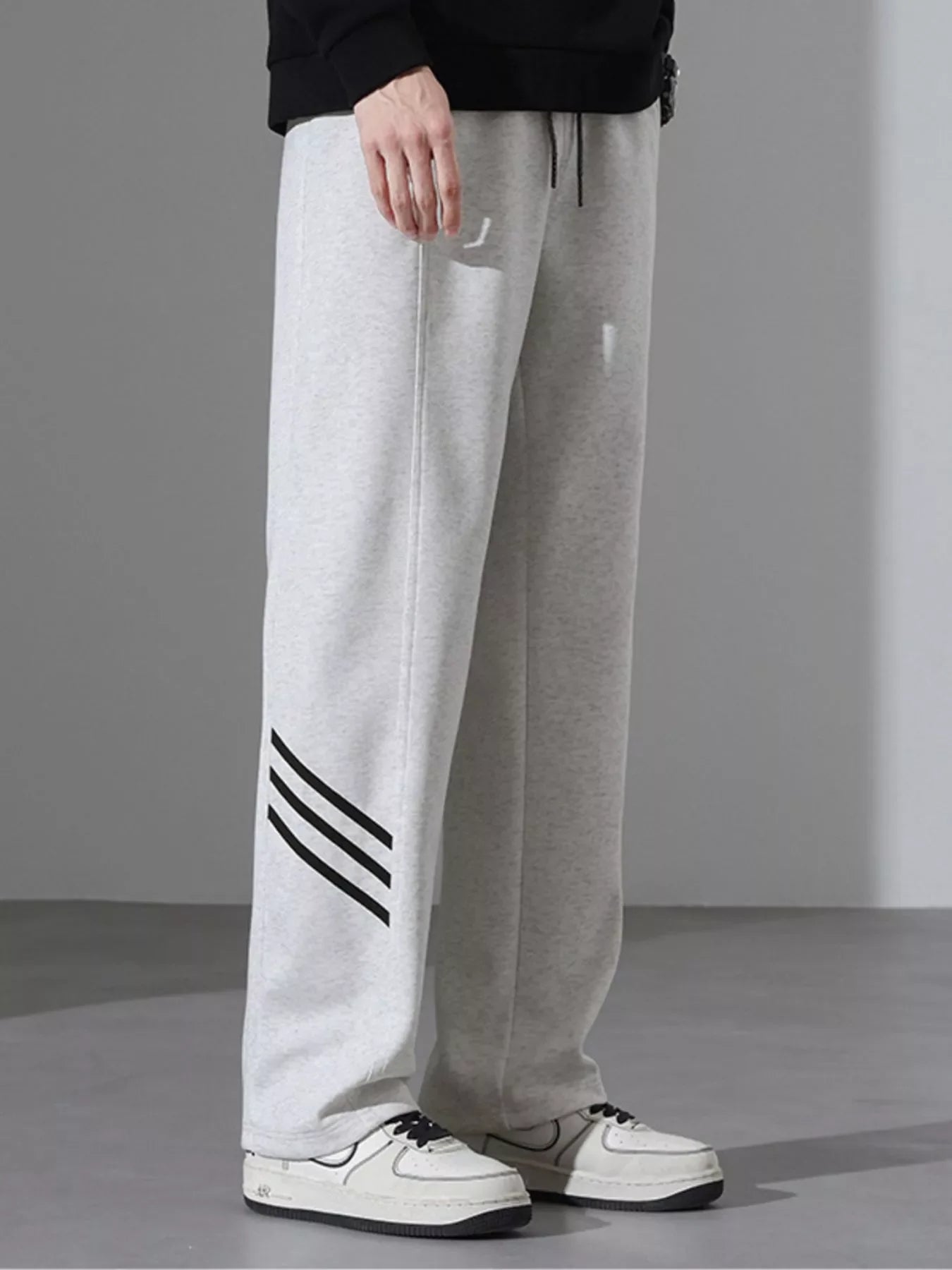 Light Flower Gray sweatpants with black stripes on the left leg, loose fit.