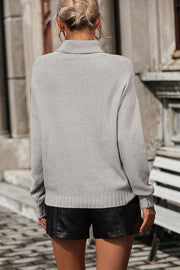 Light gray knit turtleneck sweater with a textured chevron pattern and ribbed cuffs.