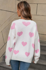 White acrylic sweater with pink intarsia hearts, crew neck, long sleeves.