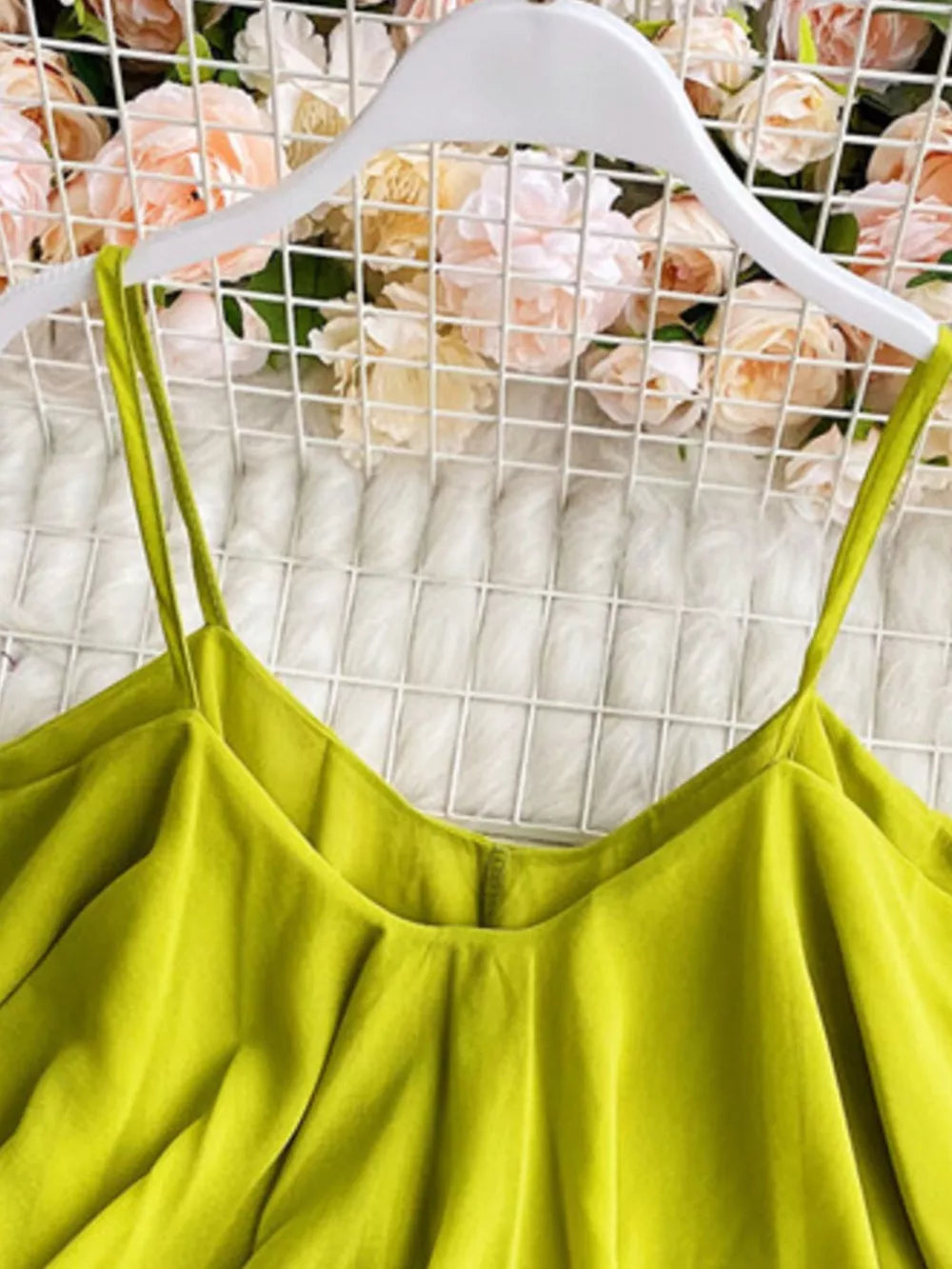 Light green camisole with spaghetti straps and delicate ruffles.