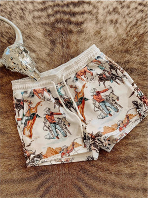 Rodeo print drawstring shorts with a white background and elastic waistband.