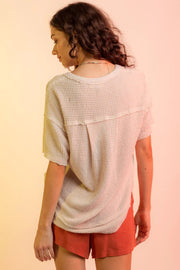 Relaxed waffle knit V-neck top in pale blush with short sleeves and a relaxed fit.