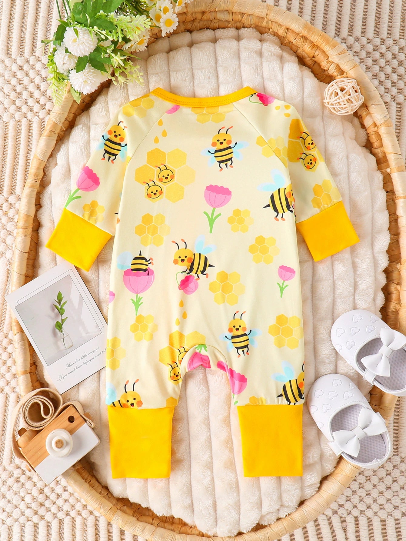 Yellow baby one-piece with bee and honeycomb print, long sleeves, yellow cuffs.