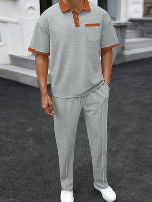 Gray textured polo shirt with contrast collar and pocket, paired with matching track pants.