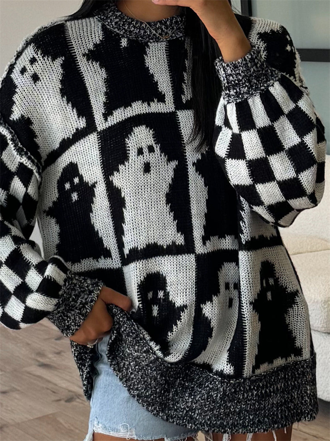 Black and white ghost checkered knit sweater with crew neck and long sleeves.