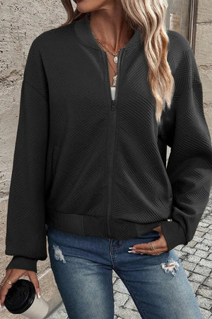 Black textured quilted bomber jacket with zipper and ribbed cuffs.