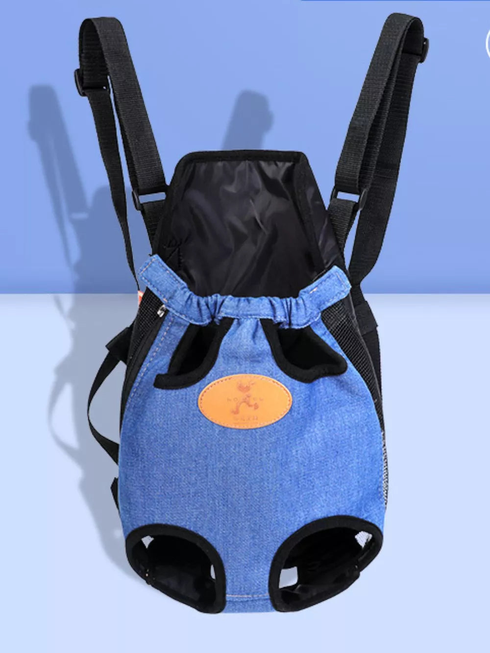Blue denim-like pet carrier backpack with adjustable straps and leg openings.