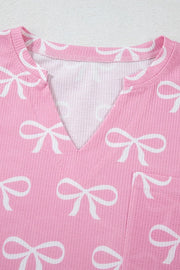 Pink ribbed lounge set with white bow print and V-neck detail.