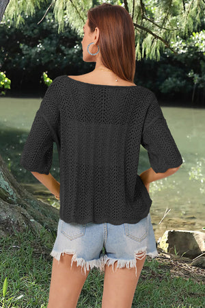Black open-knit top with scalloped short sleeves and a boat neckline.