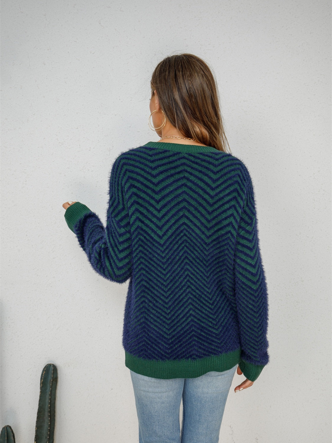 Chevron knit crewneck sweater in dark blue and green with a fuzzy texture.