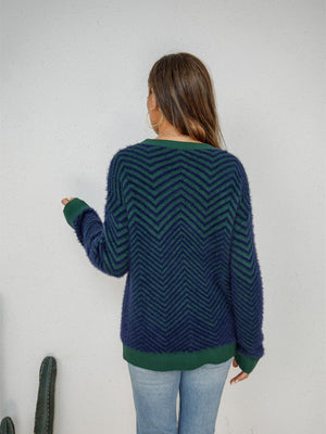 Chevron knit crewneck sweater in dark blue and green with a fuzzy texture.