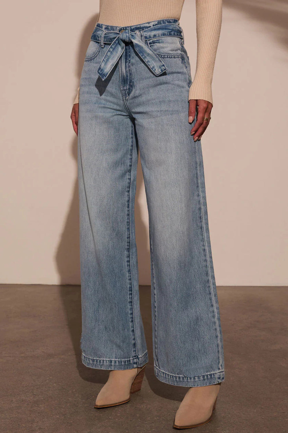 Belted wide-leg denim trousers in medium wash with a tie waist.