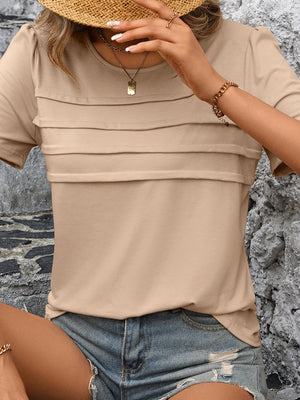Tan jersey top with horizontal pleated bodice detail and short sleeves.