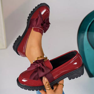 Burgundy patent loafers with bow detail and lug sole.