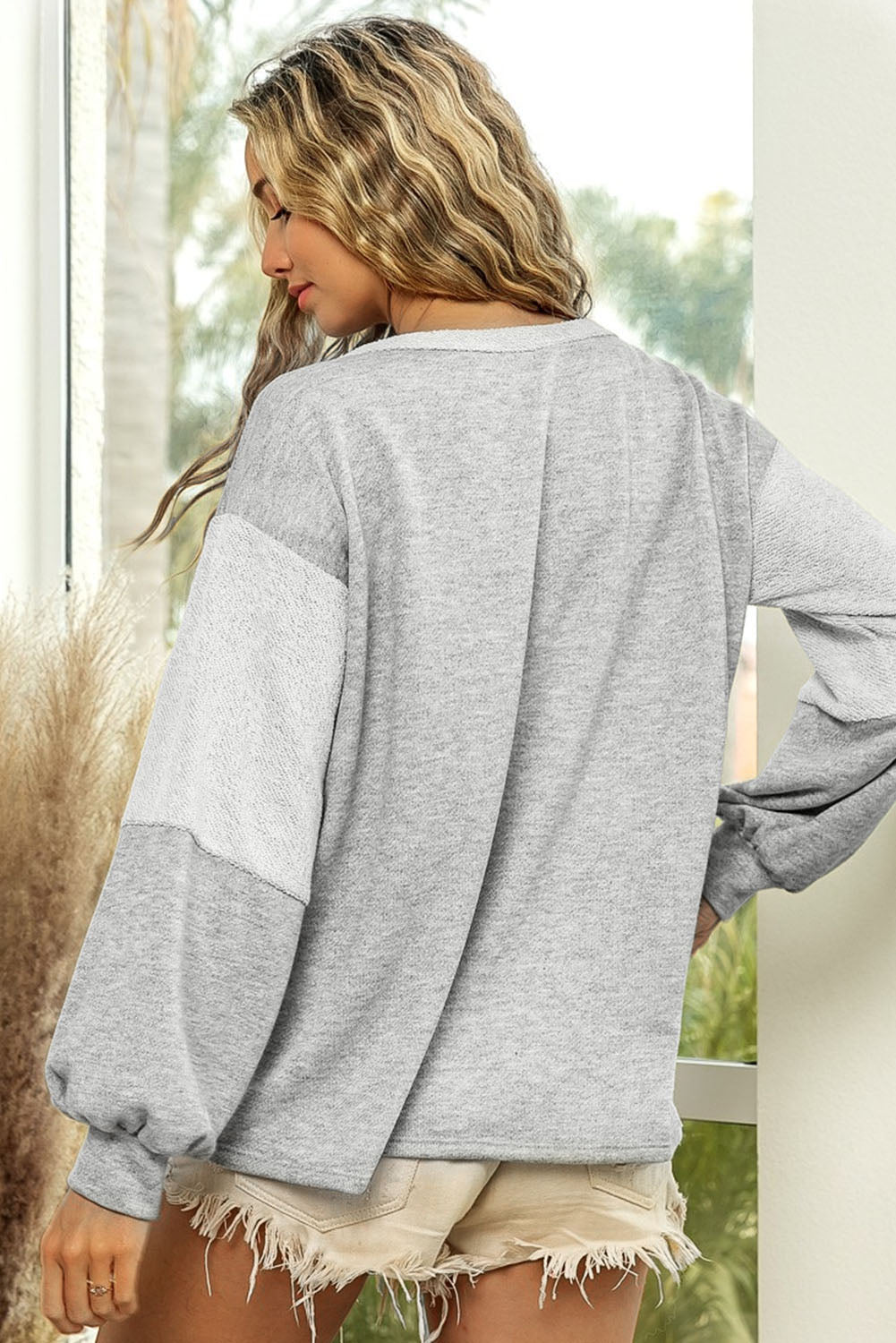Colorblock sweatshirt in light gray with a slouchy fit and textured sleeve detail.