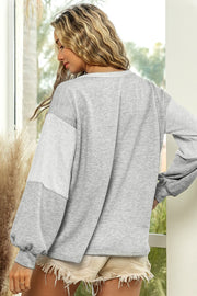 Colorblock sweatshirt in light gray with a slouchy fit and textured sleeve detail.