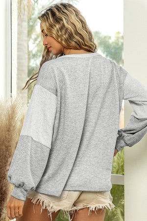 Colorblock sweatshirt in light gray with a slouchy fit and textured sleeve detail.
