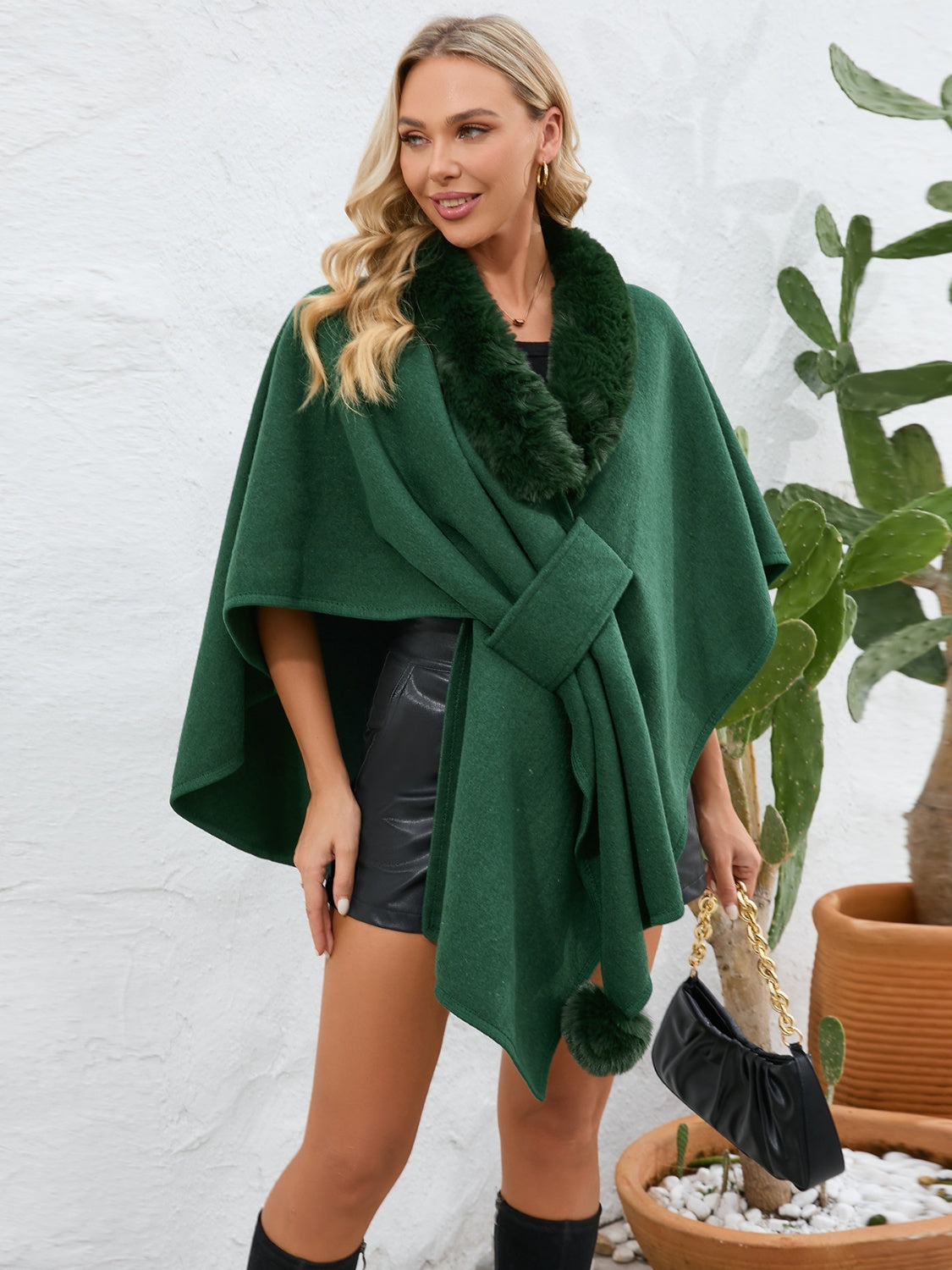 Dark green faux fur collar wrap poncho with tie closure and pom-pom detail.