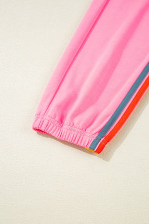 Pink track pants with rainbow stripe detail on the leg