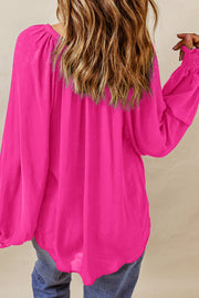 Hot pink voluminous sleeve blouse with ruched cuffs and a gathered neckline.