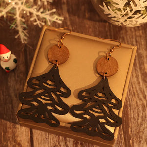 Black laser-cut pine tree earrings with wooden circle tops.
