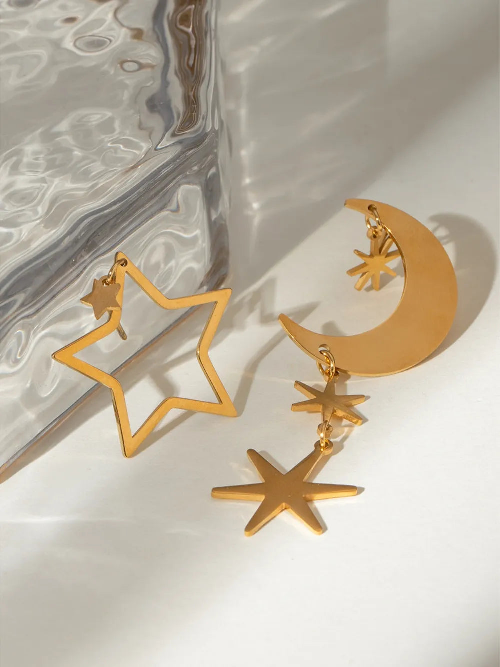 Gold star and moon drop earrings with star accents, 18K gold-plated.